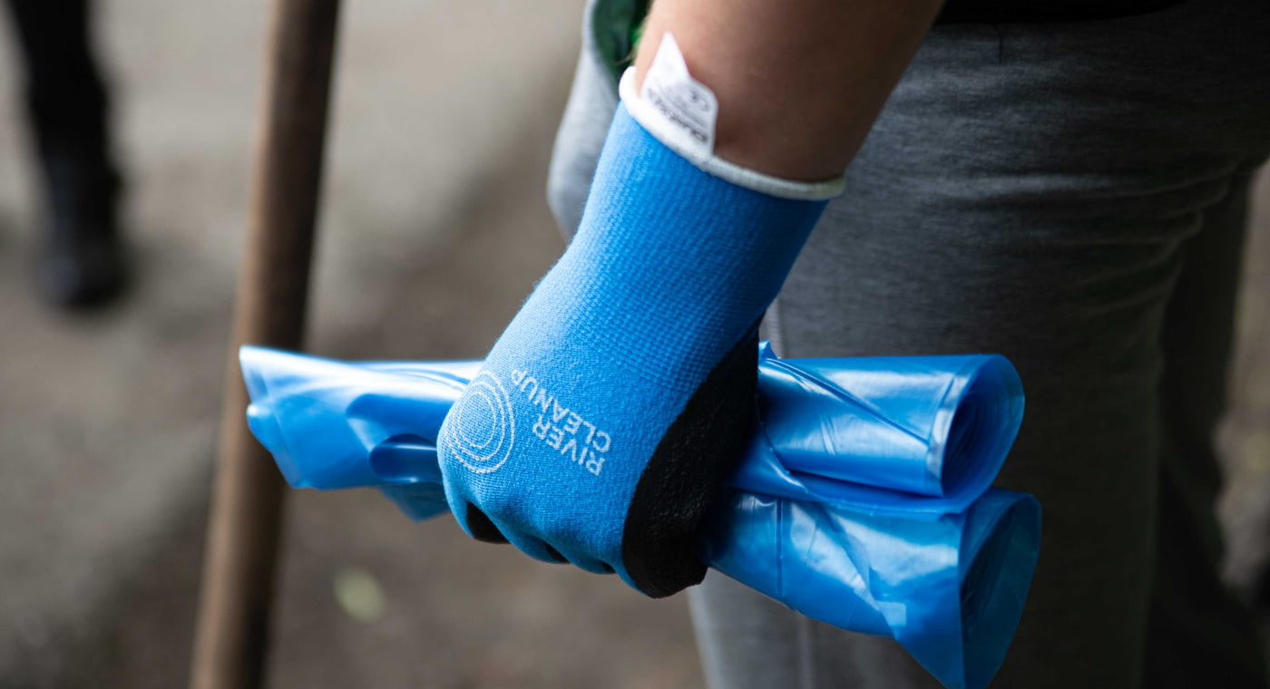 Volunteer with gloves and trash bag