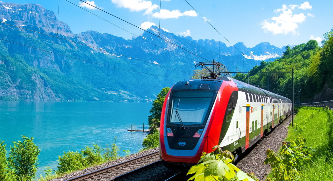 Intercity train passing lake in Switzerland